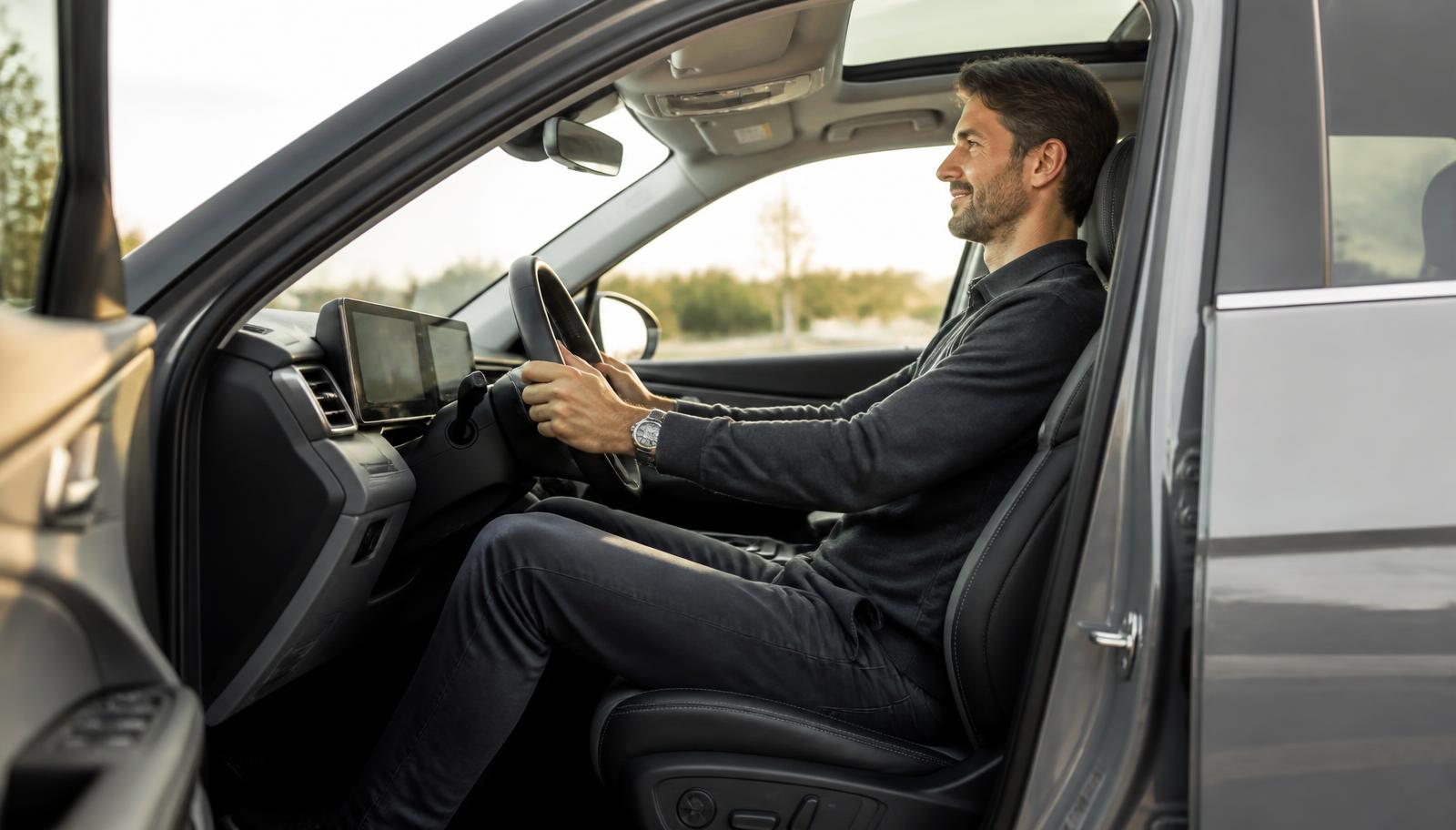 Tall driver seated comfortably behind the wheel of a modern 2026 crossover SUV with clear headroom above his head